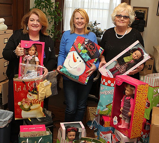 The Sentinel-Record/Richard Rasmussen HOLIDAY CHEER: Jane Jackson, right, with Jackson House Executive Director Janie Smith, left, and volunteer Georgia Dodson, donated dolls on Friday for children who are served by Jackson House during the holiday season. Dodson and her sister, Ann Taylor, hand sewed clothing for the dolls.