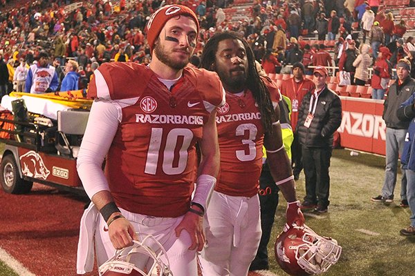 Arkansas quarterback Brandon Allen (10) and running back Alex Collins (3) walk off the field following the Razorbacks' 51-50 loss to Mississippi State on Saturday, Nov. 21, 2015, at Razorback Stadium in Fayetteville. Allen tied the SEC single-game record with seven touchdown passes. 