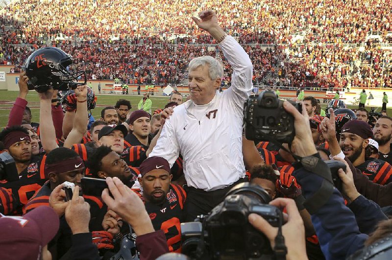 Virginia Tech Coach Frank Beamer, who coached his final home game Saturday, is carried off the field by Hokies players following a 30-27 overtime loss to No. 17 North Carolina in Blacksburg, Va.
