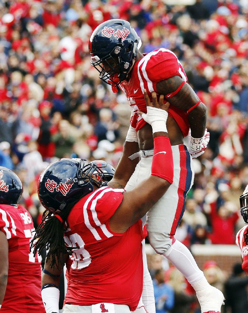 Mississippi offensive lineman Justin Bell (left) celebrates with running back Jaylen Walton after Walton’s 2-yard second-quarter touchdown run Saturday as the No. 22 Rebels defeated No. 15 LSU 38-17 in Oxford, Miss.