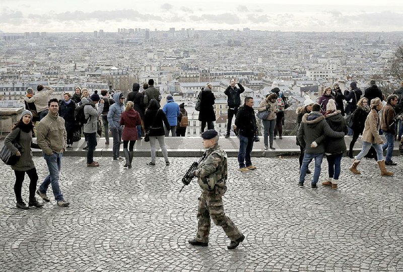 A soldier patrols Saturday outside the Sacre-Coeur Basilica atop Montmartre in Paris.