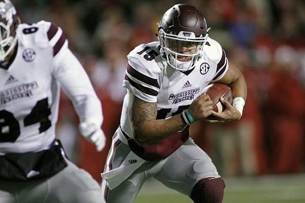 Mississippi State's Dak Prescott (15) keep the ball and runs during the the first half of an NCAA college football game against Arkansas, Saturday, Nov. 21, 2015 in Fayetteville, Ark. (AP Photo/Samantha Baker)
