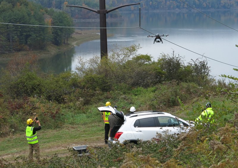 In a Wednesday, Oct. 21, 2015, photo, personnel from Boulder, Colo.-based bizUAS Corp. demonstrate the use of a Cyberhawk octocopter drone for power line inspections at a New York Power Authority hydroelectric generating site in the Catskills, near Blenheim, N.Y. From routine inspections to catastrophic storm response, utilities are turning to drones to save money and improve safety in maintaining their networks of power lines and transmission towers, but remain hobbled by strict federal regulation of the aircraft. 