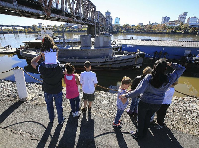 Spectators take in the arrival of the tugboat Hoga on Monday at the Arkansas Inland Maritime Museum in North Little Rock. The former U.S. Navy vessel, which is owned by the city of North Little Rock, was awarded National Historic Landmark designation in 1989 for its crew’s efforts during and after the Japanese attack on Pearl Harbor on Dec. 7, 1941. See more photos at arkansasonline.com/galleries.