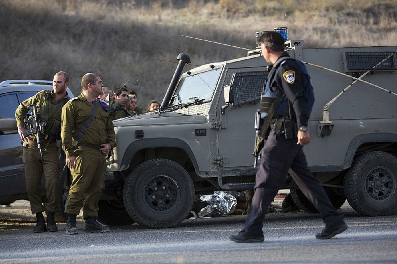 Israeli soldiers stand Monday at the scene of a stabbing attack at the Hawara checkpoint near of the West Bank city of Nablus.