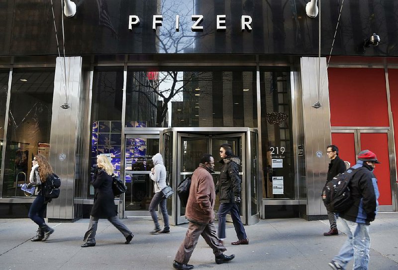 Pedestrians pass Pfizer’s headquarters building Monday in New York.