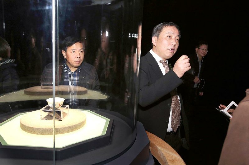 Chinese billionaire and art collector Liu Yiqian (right) speaks at a ceremony in December 2014 to mark the opening of an exhibition in Shanghai that included a $36 million Ming Dynasty tea cup (at left) that he bought with his American Express card.
