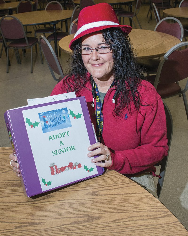 Holly Whitney, the White County Aging Program’s administrative assistant, holds a  binder that she uses to keep files of participants of the Aging Program’s Adopt a Senior project. The program has seniors from across the region send, wish lists that members of the public can take on to fulfill.