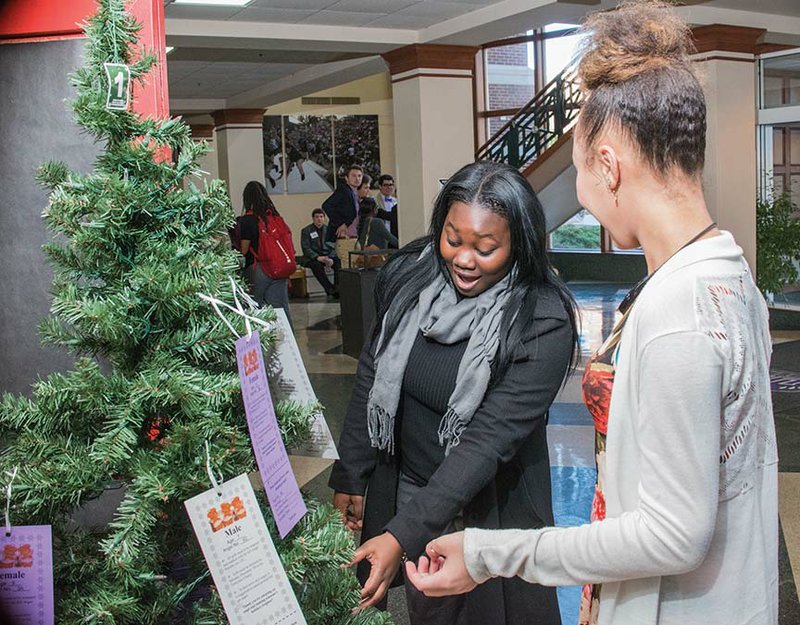 Kenya Lacy, left, and Jasmine Richardson, both 16 and students at J.A. Fair High School in Little Rock, look at the Angel Bear Tree in the lobby of the University of Central Arkansas Student Center in Conway. The two were attending the Model U.N. competition last week on campus. UCA employees and their children can apply to be on the Angel Bear Tree to receive gifts at Christmas.