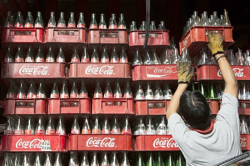 A worker loads a truck with empty Coca-Cola bottles in Mexico City in this file photo. Coca-Cola’s CEO has admitted that “there was not a sufficient level of transparency” in the company’s dealings with the Global Energy Balance Network. 
