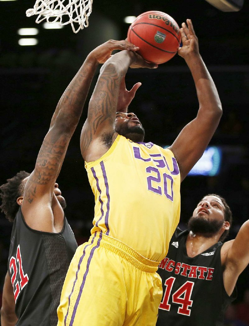 LSU forward Brian Bridgewater (20) loses the ball as he goes to the basket against North Carolina State’s BeeJay Anya (left) and Caleb Martin in the Wolfpack’s 83-72 overtime victory Tuesday. 