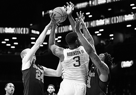 The Associated Press HOLD THAT TIGER: North Carolina State guard Maverick Rowan (24) and forward BeeJay Anya (21) defend against LSU center Elbert Robinson III (3) in the first half of the Legends Classic third-place game Tuesday night in New York. After losing to Marquette in the semifinals Monday night. No. 22 LSU fell to the Wolfpack 83-72 in overtime.