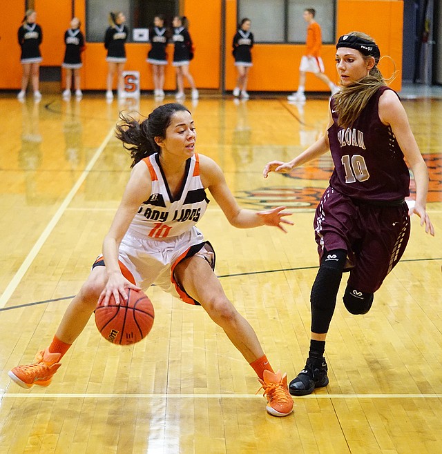 Photo by Randy Moll Berenice Garcia, Gravette sophomore, is guarded by Gabrielle Hufford, Siloam Springs senior, under the basket during play between the two teams in Gravette on Thursday, Nov. 19, 2015.