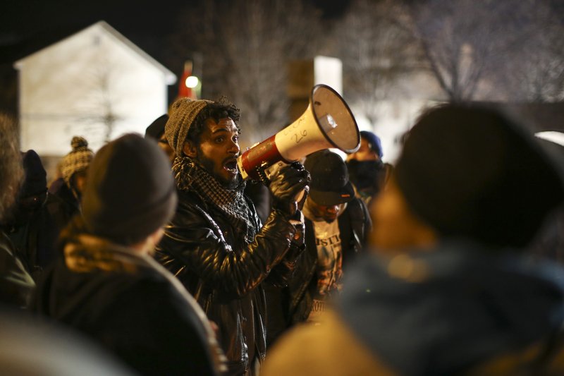 A demonstrator speaks about his encounter with attackers who were shooting at five protesters near the Minneapolis Police 4th Precinct earlier in the night, as protesters gather in front of the precinct in Minneapolis on Tuesday, Nov. 24, 2015. 