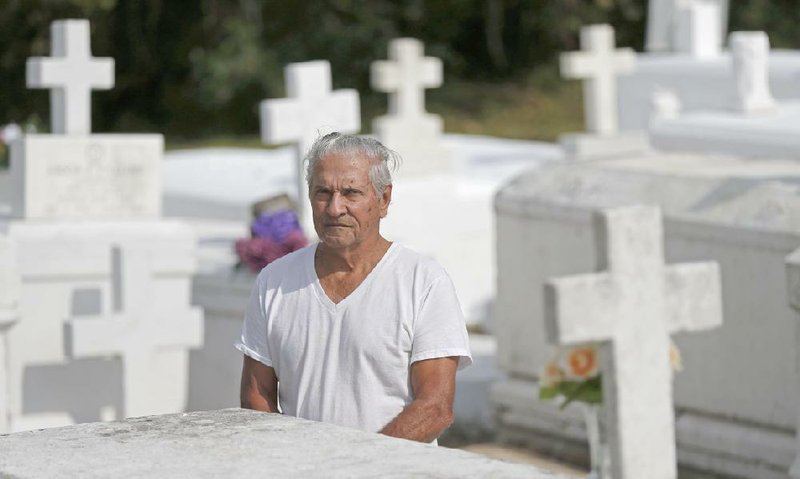 Giovanni Santini visits his wife’s grave in Lafitte, La., in October. Santini has spent decades trying to get federal recognition for his Houma tribe in south Louisiana.