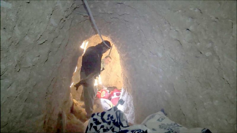 Kurdish fighters look through a tunnel complex beneath the city of Sinjar in northern Iraq used by Islamic State militants before the city was retaken.