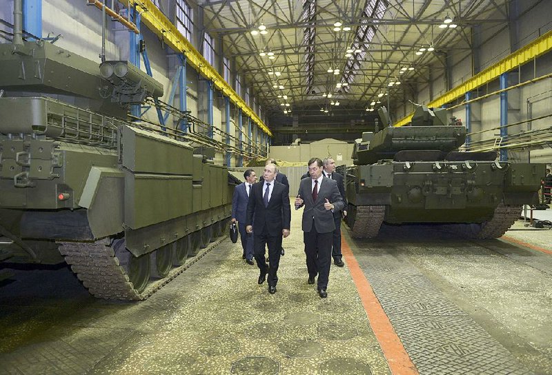 Russian President Vladimir Putin (foreground left) tours an armored-vehicle factory Wednesday in the Ural Mountains.