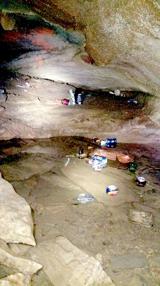 Photo submitted Beer and soda cans, glass bottles and other trash litter the floor of a cave in McDonald County near Jane that was recently vandalized, the Missouri Bat Census reported.