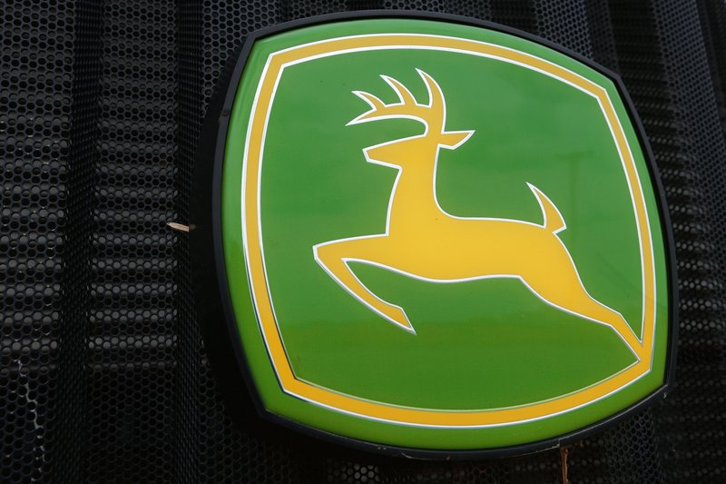 This June 8, 2014 file photo shows the John Deere farming logo at a farming equipment dealership in Petersburg, Ill. Even though sales of its green tractors, dozers and other equipment fell sharply, Deere & Co. reported better-than-expected fourth-quarter earnings as it cut costs.  