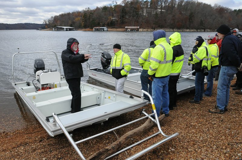 Tony Lumpkin (left), boat designer, explains Saturday Nov. 21, 2015 the features of two rescue boats that were demonstrated at Beaver Lake to firefighters and other rescue personnel who respond to emergencies on the lake. 