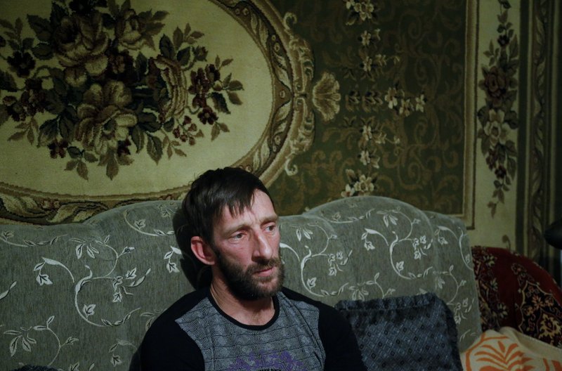 In this photo taken Thursday, Nov. 12, 2015, Abdulla Magomedov, brother of Rashid Magomedov who left to become an Islamic State fighter and was killed in Syria, sits at home in the village of Komsomolskoye, Dagestan, Russia. 
