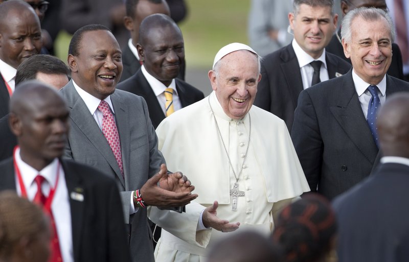 Pope Francis (center) is accompanied by Kenya’s President Uhuru Kenyatta (left) and Deputy President William Ruto (center-left) on his arrival Wednesday at the airport in Nairobi, Kenya