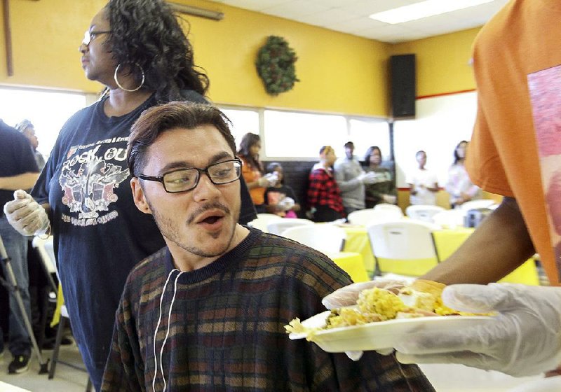 Austin Horton, 22, is served a Thanksgiving meal by volunteers at The Salvation Army’s Center of Hope Shelter in Little Rock on Thursday. Horton, who is homeless, has been in Little Rock for about a week after hitchhiking from Las Vegas.