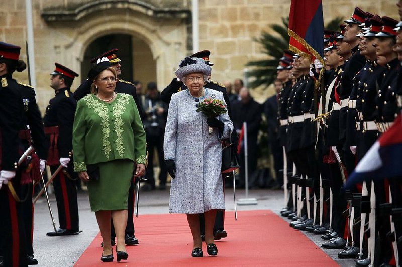 Queen Elizabeth II (right), with President Marie-Louise Coleiro Preca review the honor guard during the official welcome ceremony at St. Anton presidential palace Thursday in Valletta, Malta. 