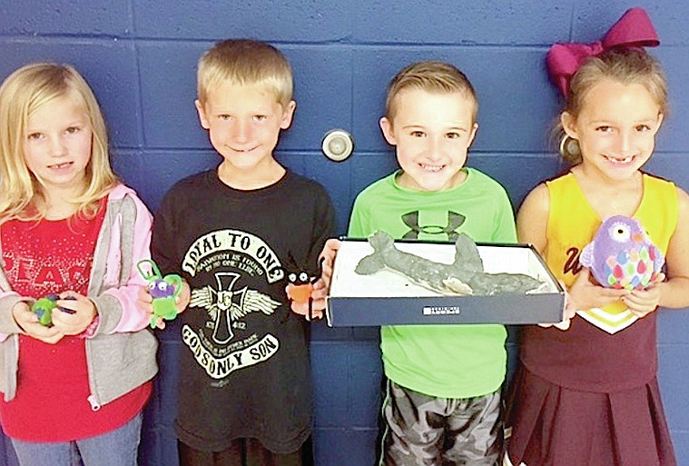 Submitted photo First-grade students, from left, Rylee Cates, D.J. Wilson, Dakota Brantley and Graycen Givens display animal models they made in Cyndi Weatherford's class at Lake Hamilton Primary School. The class created animal models to accompany their research and writing for the literacy unit, "Amazing Animals."
