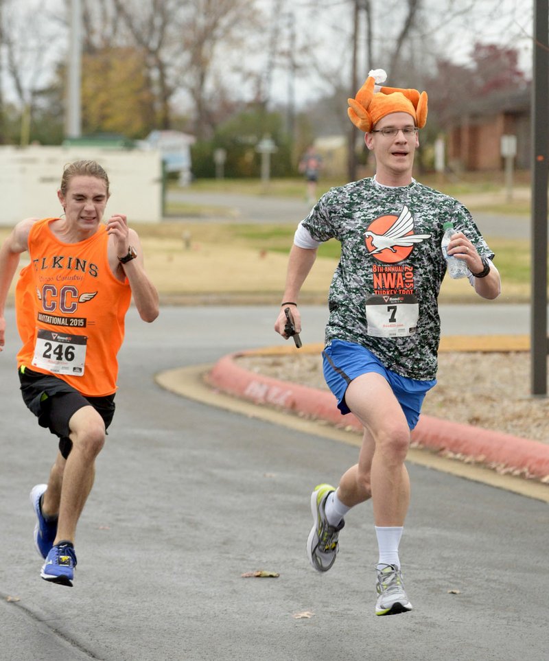Ike McClane (left) and Michael Kaiser of Jersey City, N.J., sprint to the fi nish line Thursday during the 8th annual NWA Turkey Trot 5K sponsored by Sheep Dog Impact Assistance. Proceeds from the event are used for Christmas presents for children of veterans and first responders in need.
