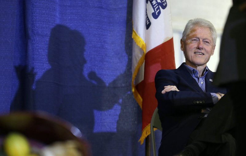 In this Nov. 15, 2015 file photo, former President Bill Clinton listens to his wife, Democratic presidential candidate Hillary Rodham Clinton speak in Ames, Iowa. 