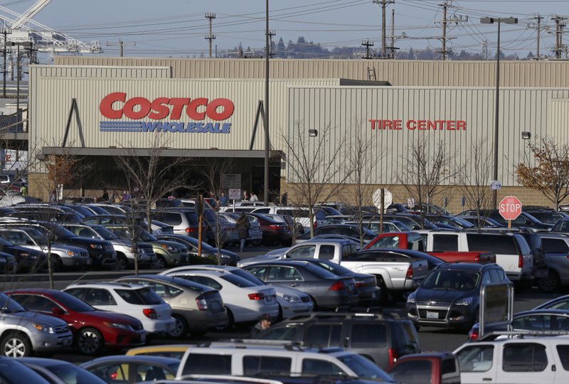 Cars fill the parking lot of a Costco store, Tuesday, Nov. 24, 2015, in Seattle. Health authorities say chicken salad from Costco has been linked to at least one case of E. coli in Washington state.