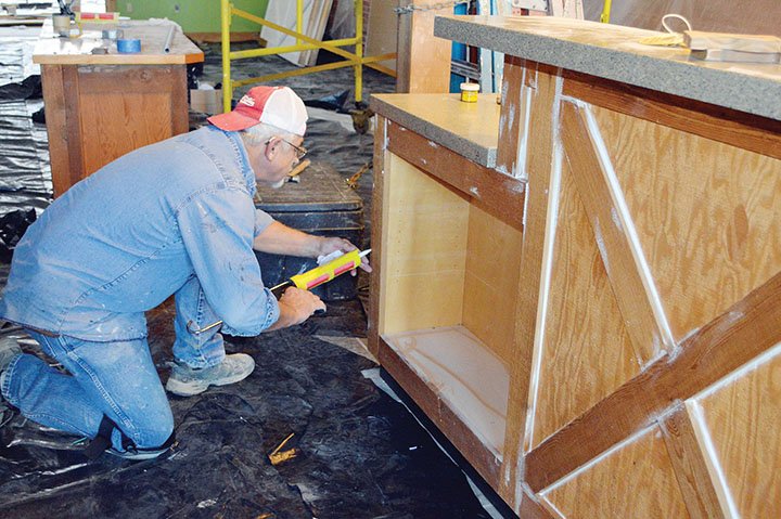 Gary Hartsfield, an employee at the University of Central Arkansas physical plant, caulks a cabinet in the building that is being renovated for a new program, UCA Downtown. Programs, classes and lectures will be held in the space at 1107 Oak St. in Conway. An open house is scheduled for 5-7 p.m. Dec. 12, also the day of the Conway Christmas Parade. Hot chocolate and purple-and-white candy canes will be given out, said Shelley Mehl, associate vice president for outreach and community engagement.