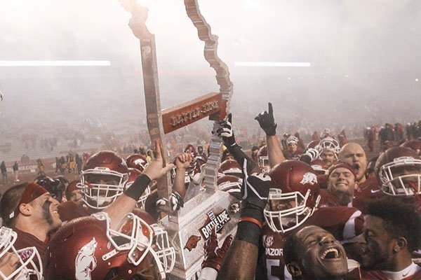 Arkansas players lift the Battle Line Trophy after beating Missouri 28-3 on Friday, Nov. 27, 2015, at Razorback Stadium in Fayetteville. 