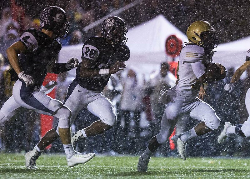 Pulaski Academy running back Jaren Watkins (right) runs away from Little Rock Christian’s Jack Lee (left) and Carlos Stewart to score a touchdown during the first quarter of Friday’s Class 5A semifinal game at Warrior Field. Watkins rushed for 210 yards and two touchdowns in the Bruins’ 42-7 victory.