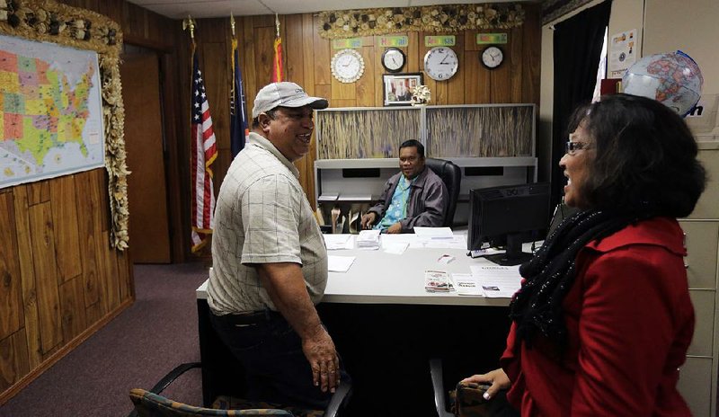 Marshallese Counsel General Carmen Chong Gum (right) talks with Larry Muller at her office in Springdale, Ark.