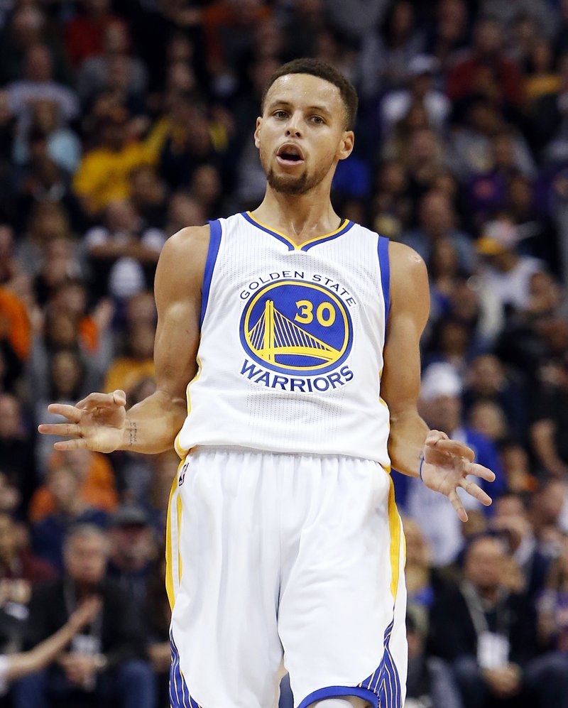 Golden State Warriors guard Stephen Curry reacts after scoring a three-point basket in the first quarter during an NBA basketball game against the Phoenix Suns, Friday, Nov. 27, 2015, in Phoenix. 