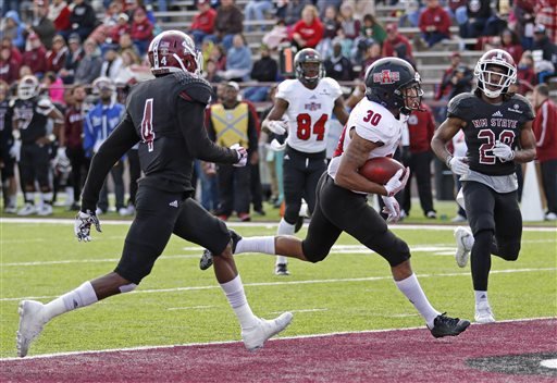 Arkansas State running back Johnston White scores a touchdown past New Mexico State defensive back Lewis Hill, right, and defensive back Winston Rose (4) during the first half in Las Cruces, N.M., on Saturday, Nov. 28, 2015.