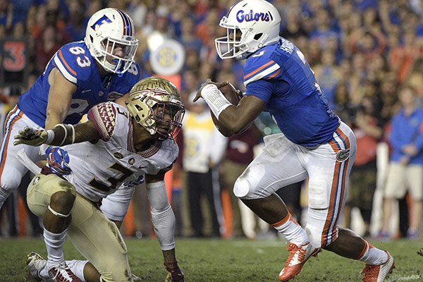 Florida quarterback Treon Harris (3) scrambles away from Florida State defensive back Derwin James (3) during the first half of an NCAA college football game in Gainesville, Fla., Saturday, Nov. 28, 2015. (AP Photo/Phelan M. Ebenhack)