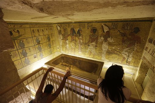 In this Thursday, Nov. 5, 2015 file photo, tourists look at the tomb of King Tut as it is displayed in a glass case at the Valley of the Kings in Luxor, Egypt. 