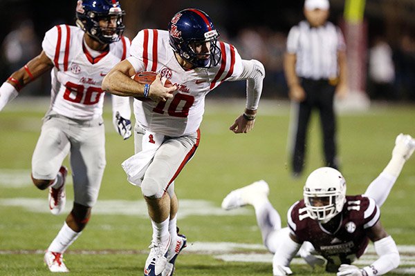 Mississippi quarterback Chad Kelly (10) runs with the ball past Mississippi State defensive back Kivon Coman (11) for a 27-yard touchdown run in the first half of an NCAA college football game against Mississippi in Starkville, Miss., Saturday, Nov. 28, 2015. (AP Photo/Rogelio V. Solis)