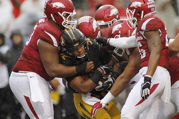 Arkansas' defense collectively takes down Missouri's Russell Hansbrough (32) during the first half of an NCAA college football game Friday, Nov. 27, 2015, in Fayetteville, Ark. (AP Photo/Samantha Baker)