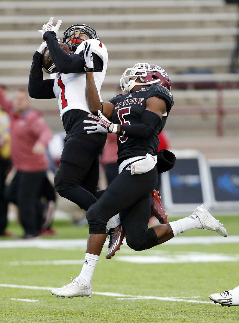 Arkansas State defensive back Blaise Taylor (left) intercepts a pass intended for New Mexico State wide receiver Tyrain Taylor (5) during the second half of the Red Wolves’ 52-28 victory over the Aggies on Saturday in Las Cruces, N.M.
