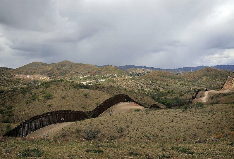 A fence marks the border between Arizona and Mexico near Nogales. “People need to wake up and realize this border is not secure,” volunteer border watcher Tim “Nailer” Foley said.