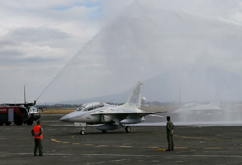 Philippine officials welcome their new FA-50 fighter jets with a water cannon salute Saturday as the planes arrive at Clark Air Base north of Manila. 
