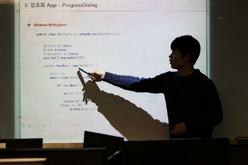 An instructor points to a line of code in the programming language Java displayed on a projection screen during a cyber-defense programming class in the “War Room” at Korea University in Seoul, South Korea, last week. 