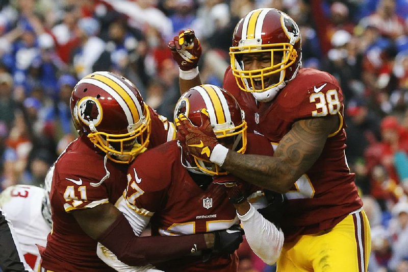 Washington Redskins cornerback Quinton Dunbar (center) is greeted by teammates Will Blackmon (left) and Dashon Goldson (38) after intercepting a pass in the end zone during the second half of Sunday’s game against the New York Giants in Landover, Md. The Redskins intercepted Giants quarterback Eli Manning three times and won 20-14.