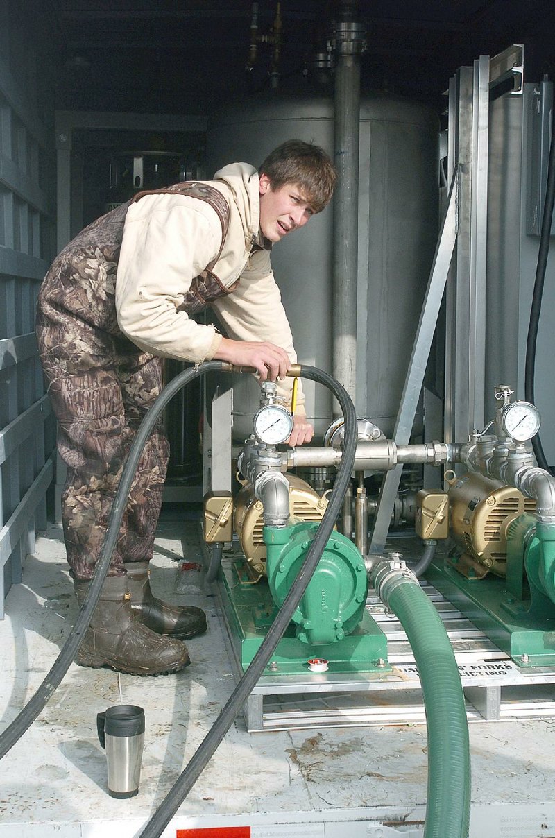 Adam Jokerst, an engineer at BlueInGreen LLC, sets up a pump. The company sells watertreatment systems that add substances including dissolved oxygen, carbon dioxide and ozone into water.