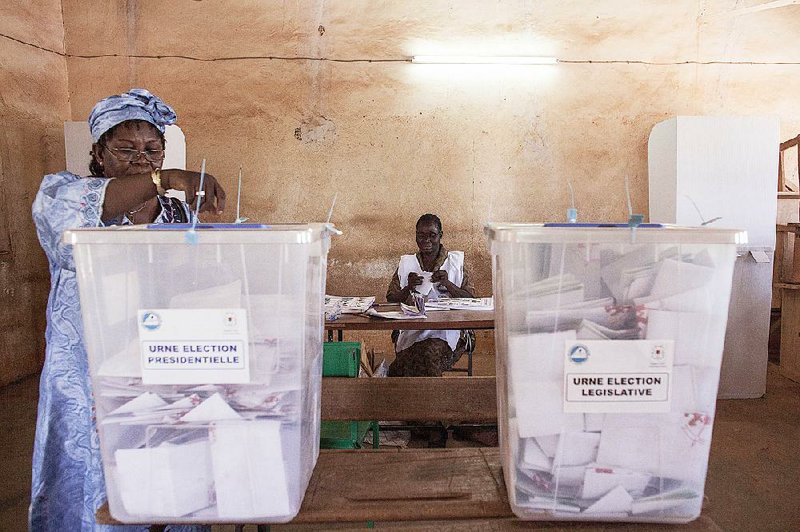 A voter casts her ballot Sunday in Ouagadougou as Burkina Faso elects a president and legislators.