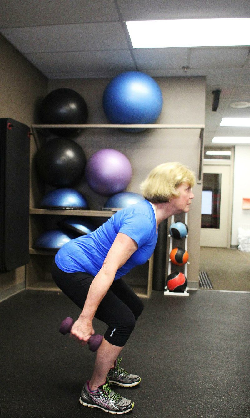 Cathy Hammons Slater does step 1 of the Dumbbell Skier Swing exercise